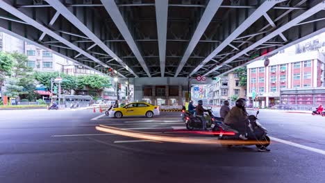 dynamic time-lapse of scooter-packed traffic jam at a busy underpass intersection in the heart of taipei city, taiwan