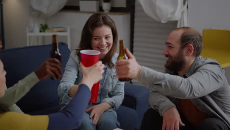 Multi-cultural-friends-cheering-beer-bottles-during-wekeend-party