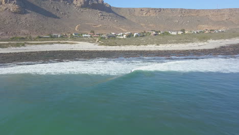 dramatic aerial of surfing along coast in south africa