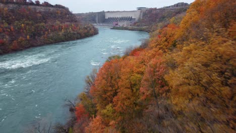 Luftaufnahme-Im-POV-Flug-Durch-Die-Niagara-Schlucht-Während-Der-Herbstsaison-Mit-Einer-Hellen-Und-Farbenfrohen-Landschaft-Darunter-Mit-Tonnen-Von-Orange--Und-Gelbtönen,-Typisch-Für-Die-Herbstsaison