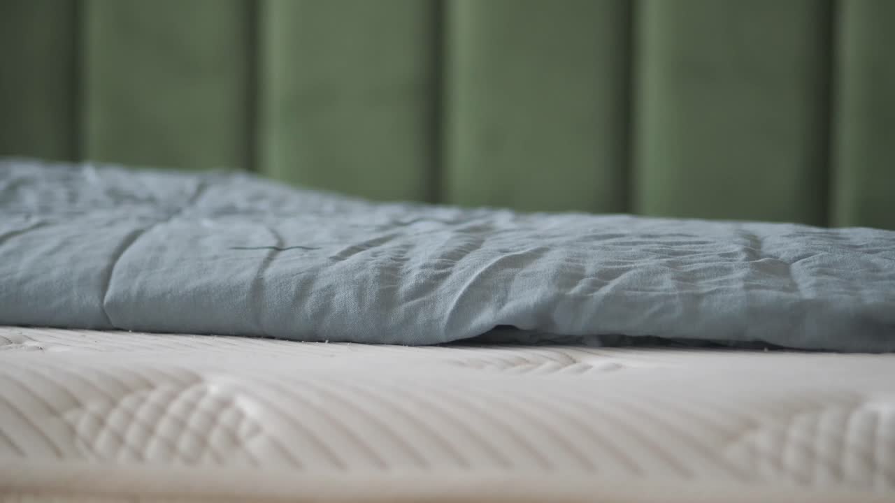 A close up shot of a bed with a sheet