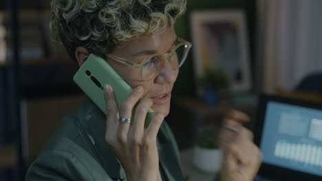 una mujer hablando por teléfono por la noche.