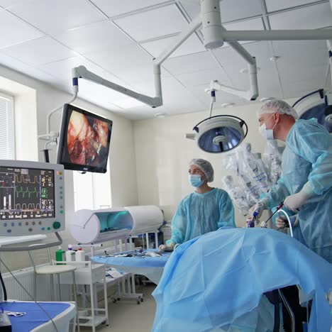 surgery room with screens and monitors. professionals having a surgery using modern equipment. wide screens showing the progress of operation