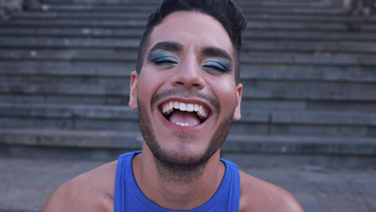 joven transgénero con maquillaje sonriendo a la cámara