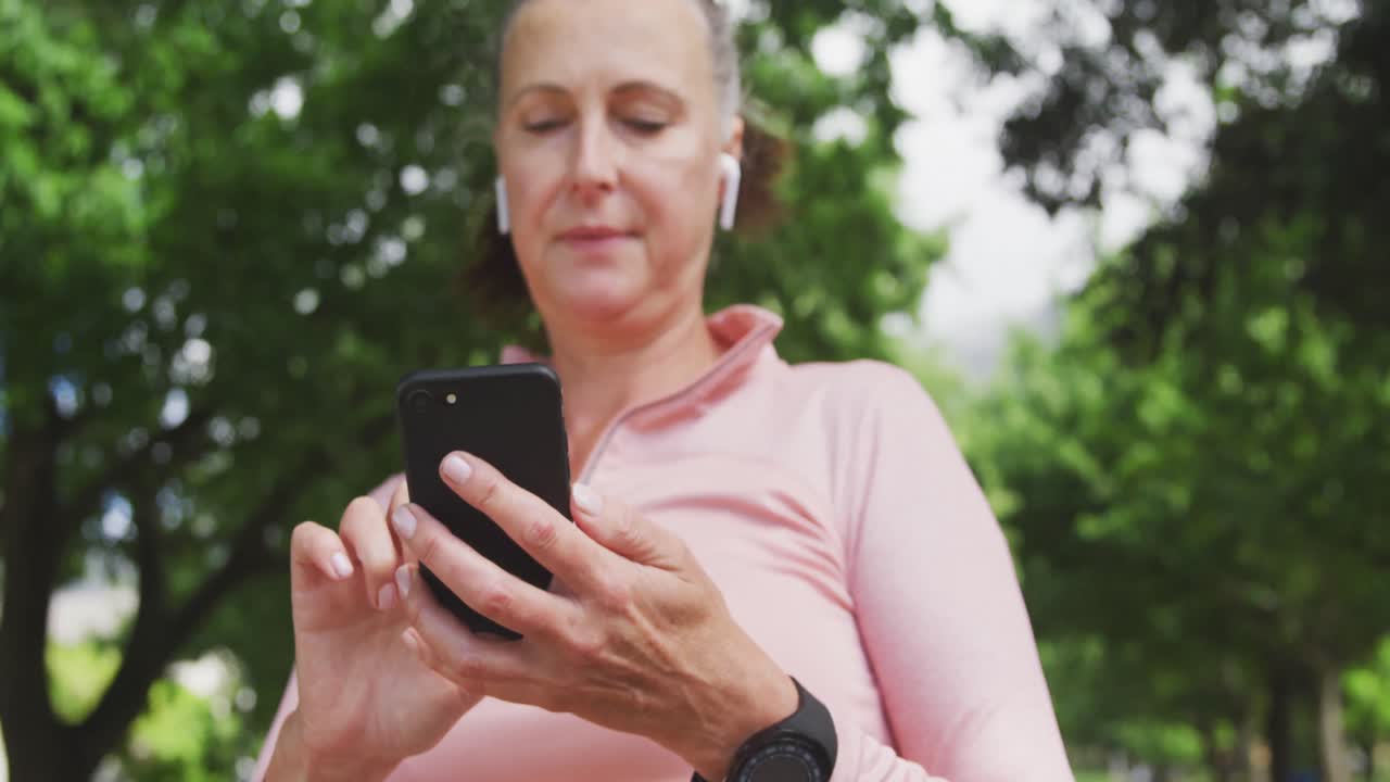 mujer mayor usando un teléfono inteligente en el parque