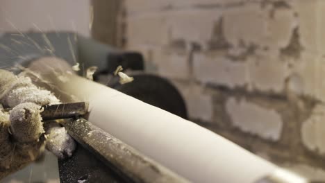 Woodworker-planing-a-table-leg-with-wood-chips-flying