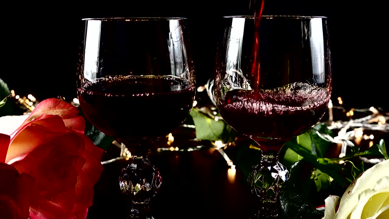 Taças de vinho e rosa contra o fundo de guirlandas brilhantes