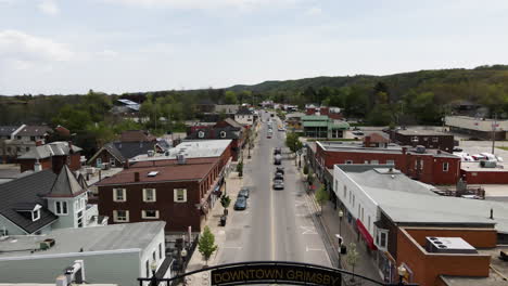 Aerial-flyover-Downtown-of-Grimsby-in-Canada-with-driving-cars-and-old-buildings-during-sunny-day,Canada