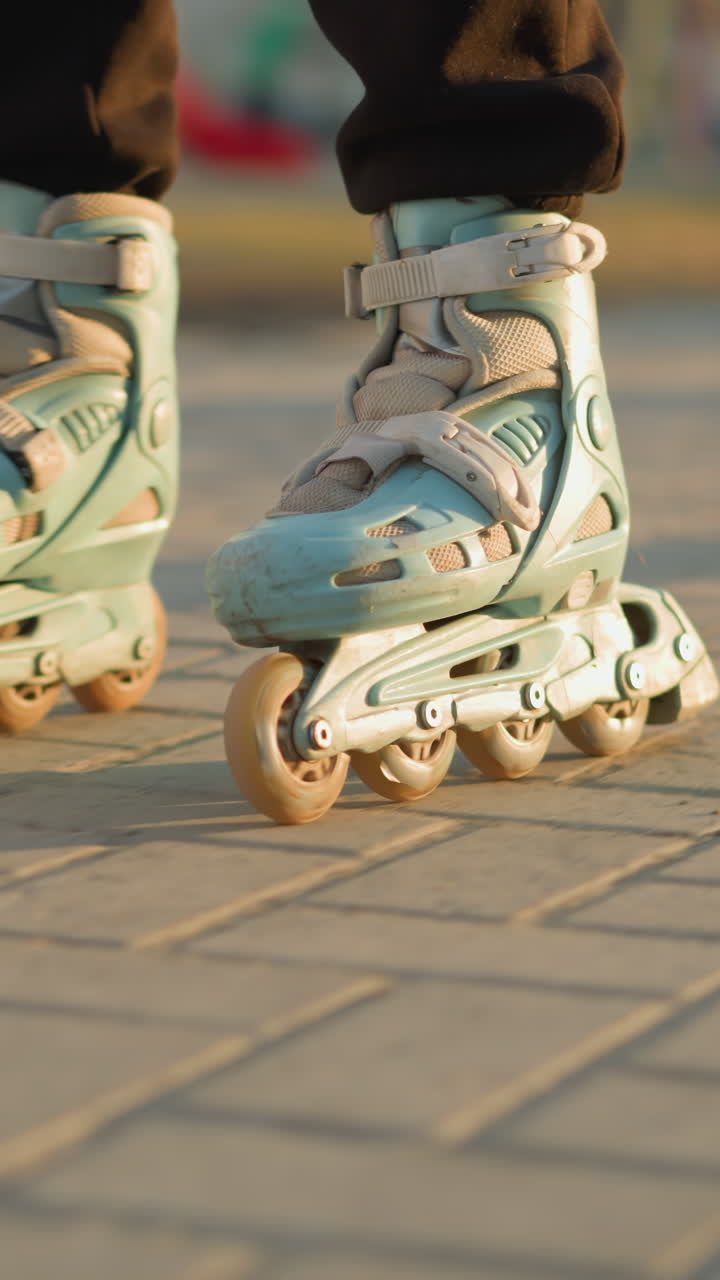 A close-up shot capturing a person s feet wearing rollerblades, smoothly gliding along a paved path in a park. with a soft focus on the background