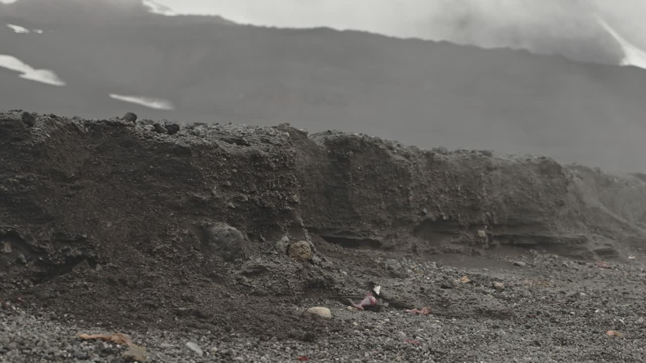 Hot steam rising from water and over a small edge of earth on desolation island in Antarctica