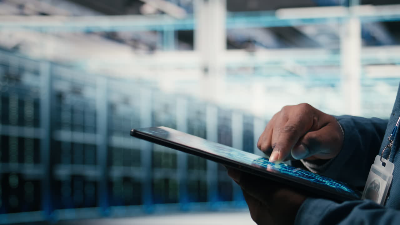 Close-Up of Hand Using Digital Tablet in Data Center