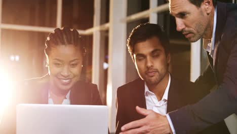 Businessman-discussing-with-colleagues-over-laptop