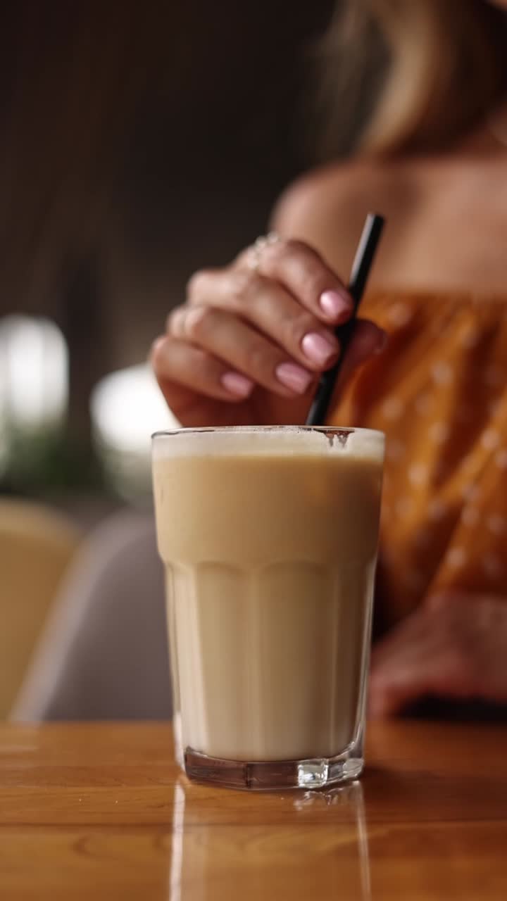 Woman enjoying an iced coffee latte at a cafe