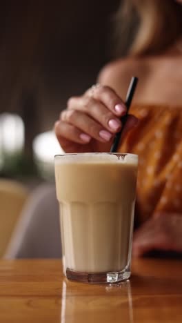 woman enjoying an iced coffee latte at a cafe