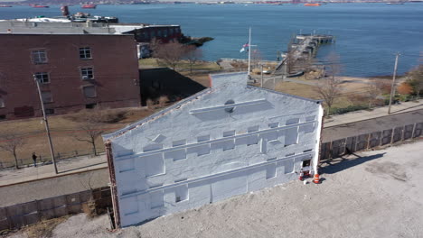 An-aerial-shot-of-an-old-building-facade,-painted-white-with-red-steel-beams-on-the-other-side