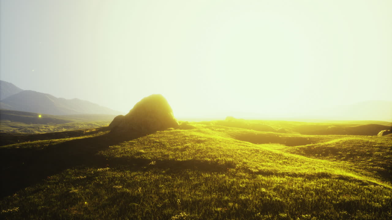 황금빛의 빛은 새벽에 언덕과 함께 평온한 풍경을 비추고 있습니다.