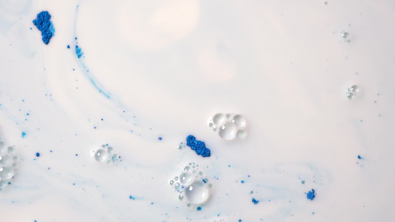 파란색 염료와 거품을 가진 추상적인 우유 예술