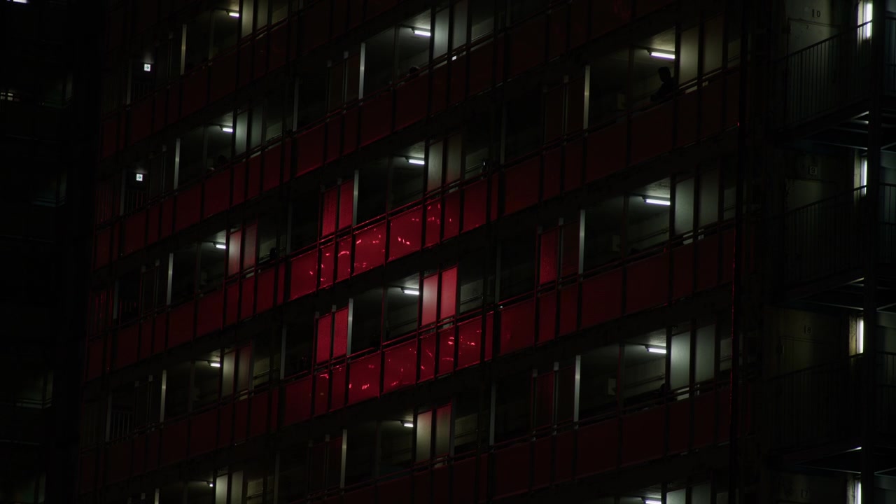 Fuochi d'artificio che si riflettono sulla facciata scura di un edificio a più piani a Tokyo, Giappone. Inquadratura ampia