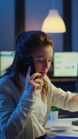 vertical video: nervous manager discussing at smartphone with employee working overtime