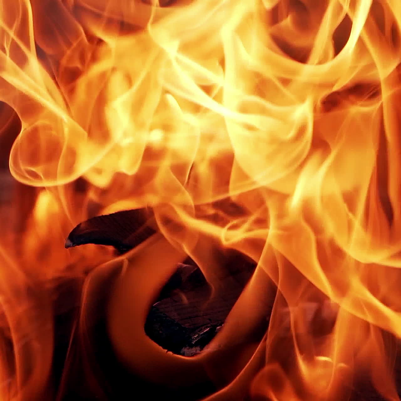 Beautiful slow motion of orange flame. Vivid flame from burning firewood. Bright fire outdoors. Close-up.