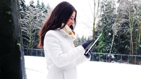 Schöne-Frau-In-Warmer-Kleidung-Mit-Digitalem-Tablet