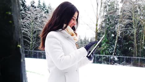 beautiful woman in warm clothing using digital tablet