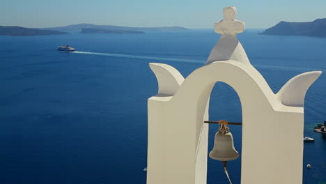 un crucero en la distancia detrás de una iglesia de una isla griega