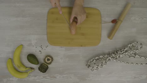 cortando una salchicha en una mesa de madera con accesorios de aventura