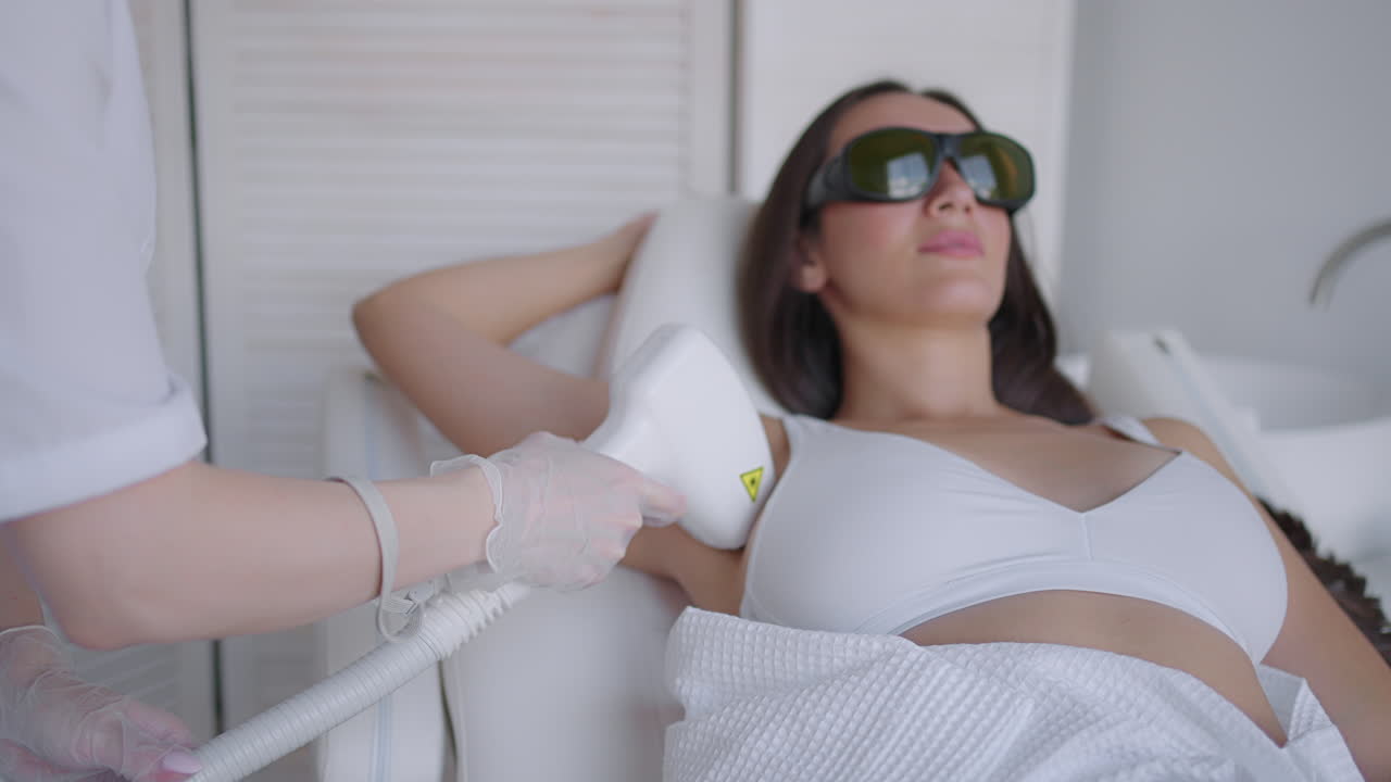 여성 미용사 는 미용실 에서 겨드랑이 의 레이저 제거 를 한다. 겨드랑이 에서 머리카락 을 제거 한다. 아름다움 과 깨 ⁇  한 피부