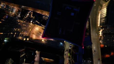 aerial drone nighttime flight over elizabeth towers in manchester city centre giving a birdseye view of the rooftop and moving traffic below