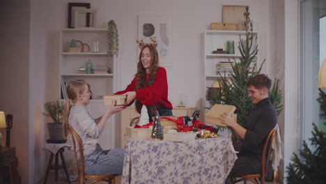 woman giving christmas presents to friends