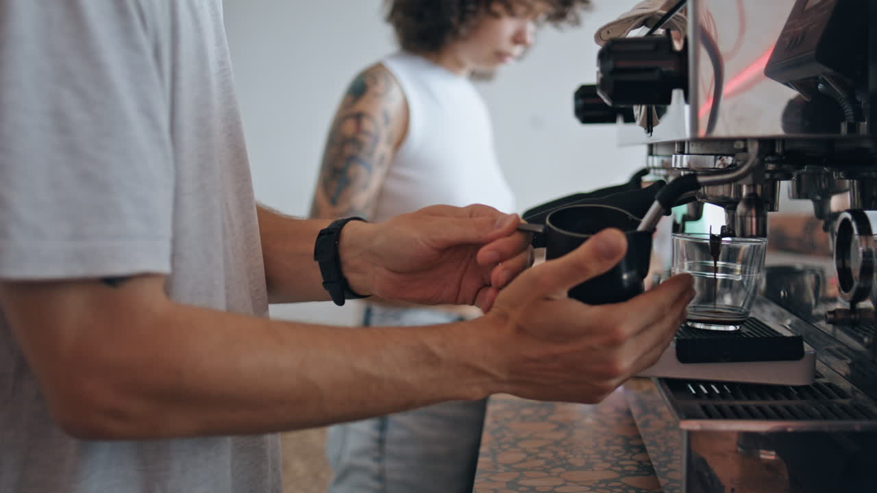 Primo piano di un barista irriconoscibile che prepara il caffè con una macchina moderna in un ristorante.