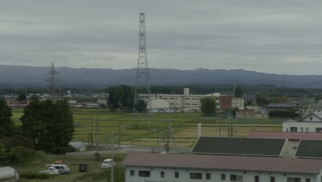 rural japan by shinkansen: fields, villages, mountains experience the charm of japan’s rural scenery on the shinkansen, with lush mountains, fields, and villages beneath overcast skies.