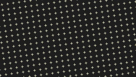 black and white geometric pattern crosses and dots on dark background