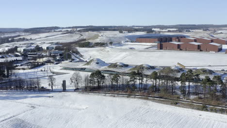 aerial view of the macallan whisky distillery surrounded by snow on a sunny winters day, moray, scotland - advancing shot