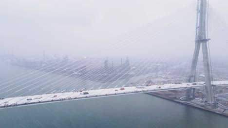snowy gordie howe bridge under construction over detroit river with detroit skyline in background