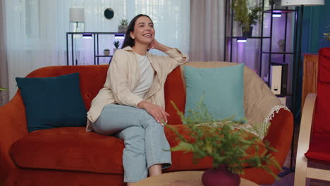 feliz mujer joven tranquila sonriendo mirando hacia otro lado soñando descansando, buenas noticias, sentirse satisfecha en casa
