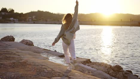 blonde woman slowly walking along stone marine