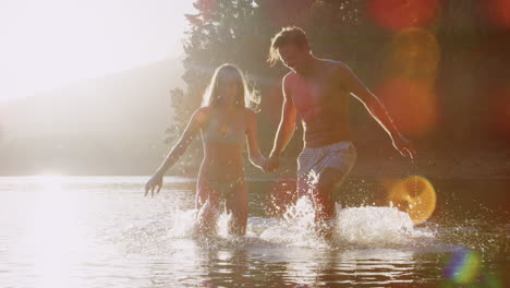 young white couple wading and having fun in a lake