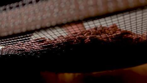 chocolate or cocoa beans drying on a mesh screen