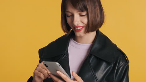 mujer sonriente con teléfono inteligente gris