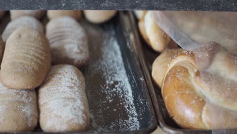 close-up of multiple trays filled with assorted baked pastries cooling on racks inside a bakery