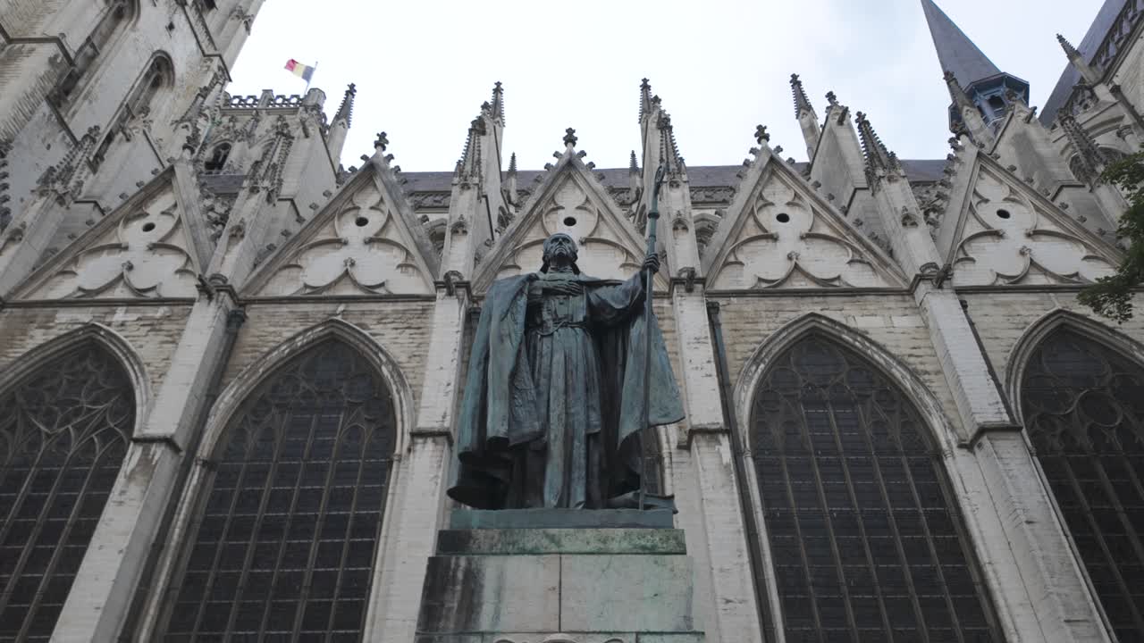 Statue of Cardinal Mercier holding a staff, located in front of the majestic St. Michael and St. Gudula Cathedral in Brussels. Pan Up
