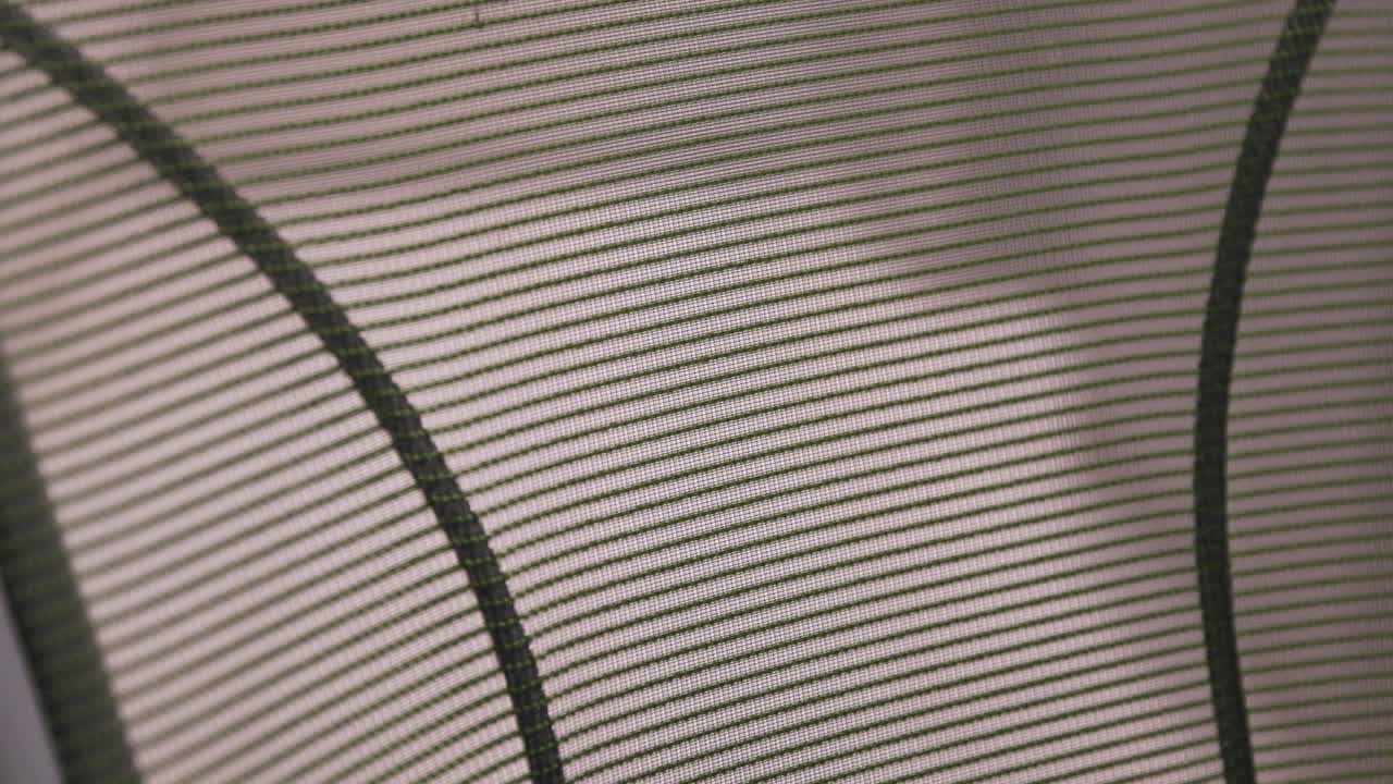 close up of a mesh back office chair that's backlit