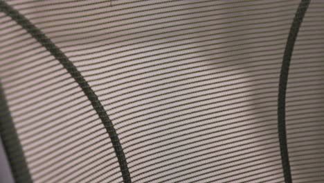 close up of a mesh back office chair that's backlit