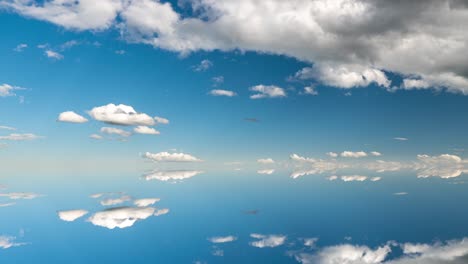 futuristic background consisting of time lapse clip of white fluffy clouds over blue sky and their reflection, video loop