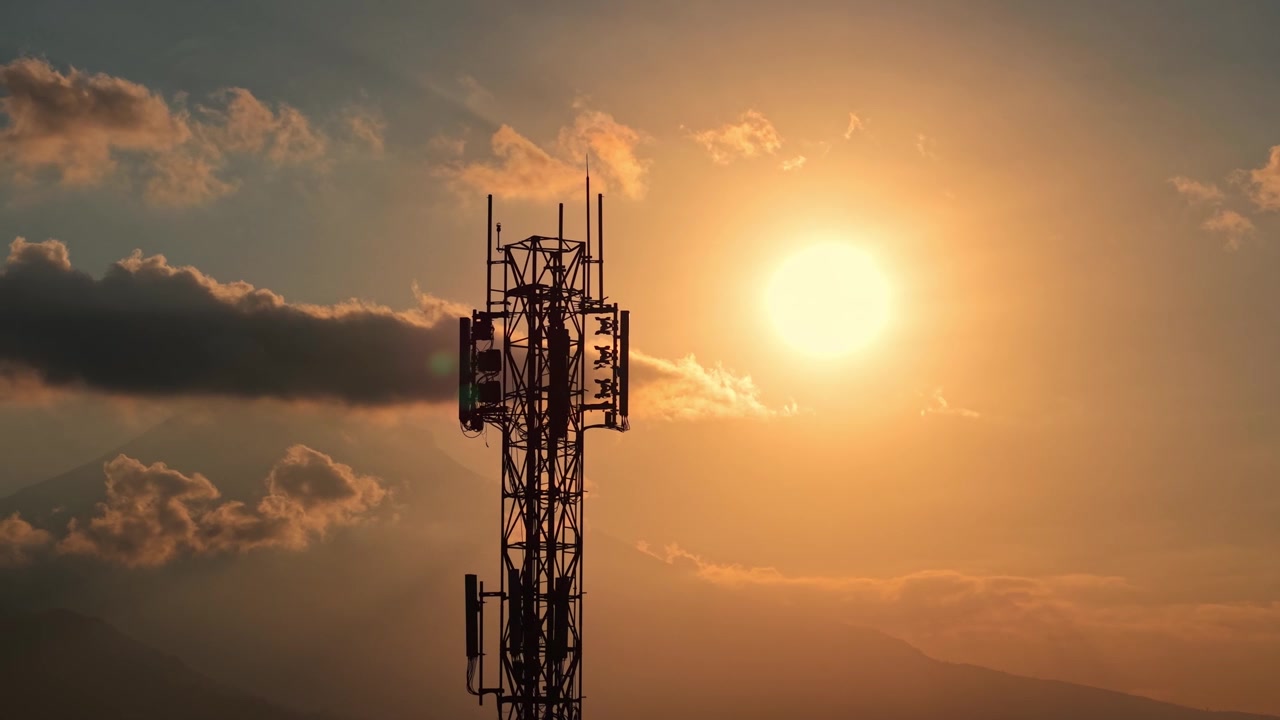 Torre di trasmissione del segnale contro lo sfondo di un tramonto dorato, scatto in silhouette. Filmato concettuale di infrastrutture di telecomunicazioni, rete e tecnologia.