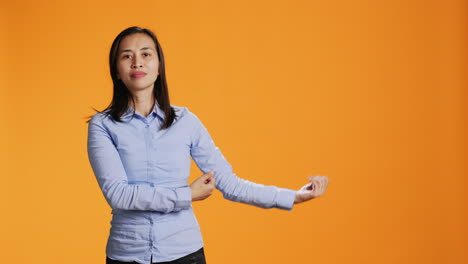 filipino woman showing something to both sides of the studio,