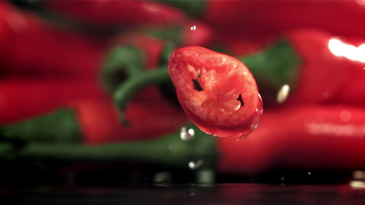 Fatia de Pimenta Vermelha Caindo em Câmera Lenta com Respingos de Água