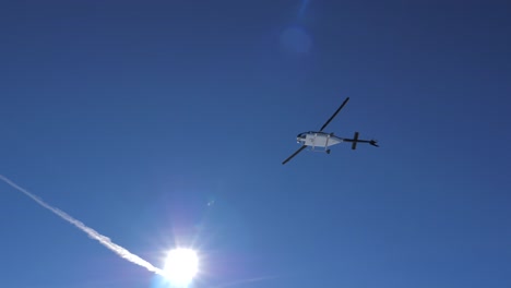 helicopter flies low in the mountains above his head in clear sunny weather